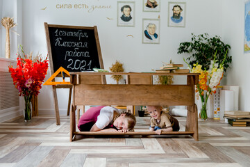 children hiding under the school desk