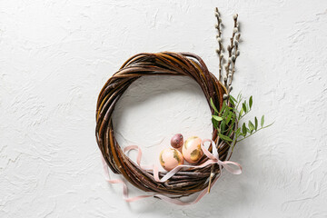 Beautiful Easter wreath with eggs and pussy willow branches on light background