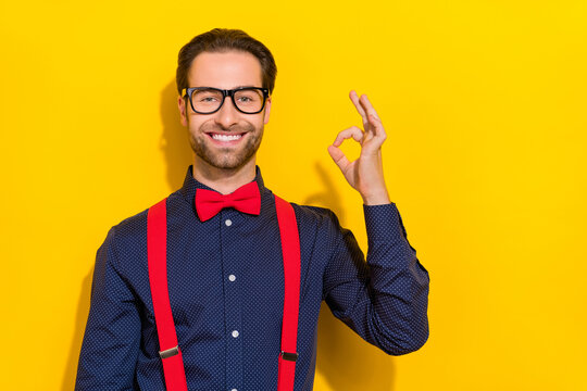 Photo of young man show fingers okey symbol feedback promo perfect isolated over yellow color background
