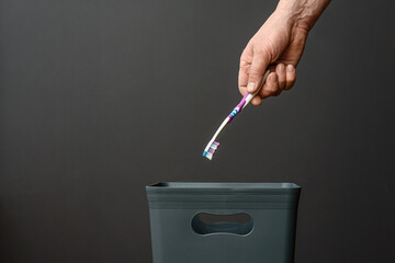 The toothbrush is thrown out of the trash after use.