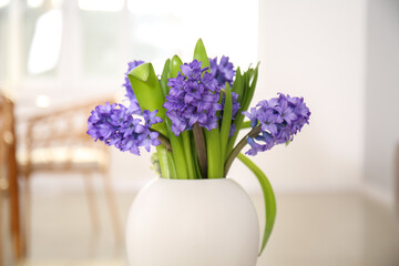 Vase with beautiful hyacinth flowers in light room, closeup