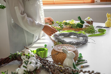 Woman making beautiful Easter wreath at table, closeup © Pixel-Shot