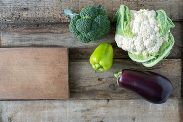 Vegetables on a wooden background. Cutting board with vegetables. Ingredients for a vegetable dish