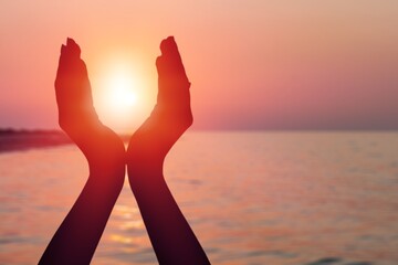 Summer sun concept with silhouette of young woman's hands relaxing, happy meditating