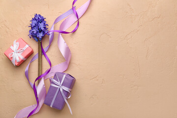 Composition with ribbons, flowers and gift boxes for International Women's Day celebration on beige background