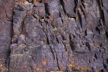 Closeup of rock surface. Textured rough dark surface. Rock wall background.