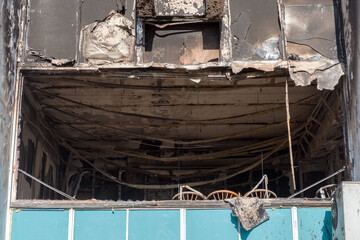 Burnt facade of building. Black walls after fire. Arson concept. Destroyed burned walls after fire extinguished.