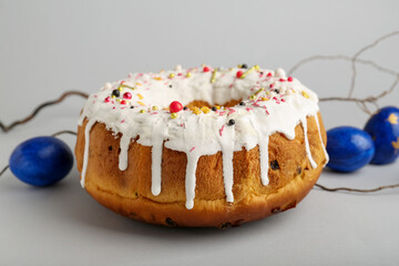 Tasty Easter cake and eggs on grey background