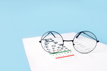 A table for checking vision and glasses on a light blue background. a concept for an ophthalmology...