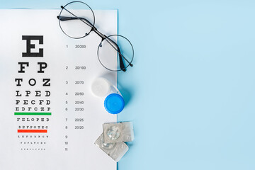 A table for checking vision in Russian, glasses and lenses on a light blue background. a concept...