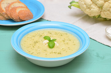 vegetable soup with cauliflower and basil in a bowl close up