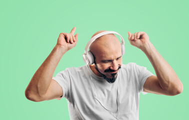 Bald man listening to music and dancing. Person with a beard and mustache enjoys music. Entertainment, sound, bass and mood