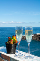 New year celebration with two glasses of champagne or Spanish cava sparkling wine and view on blue Atlantic ocean, Canary islands, winter tourists destination
