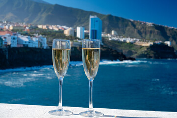 New year celebration with two glasses of champagne or Spanish cava sparkling wine and view on blue Atlantic ocean, Canary islands, winter tourists destination