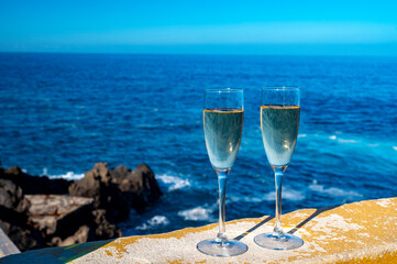 New year celebration with two glasses of champagne or Spanish cava sparkling wine and view on blue Atlantic ocean, Canary islands, winter tourists destination