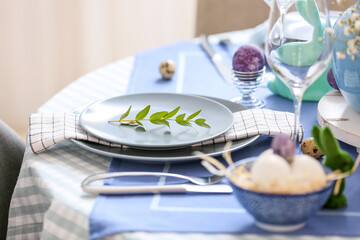 Plates decorated with eucalyptus branch on table served for Easter celebration