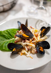 Tasty seafood salad with boiled octopus, potatoes, olive oil and mussels served in Italian restaurant