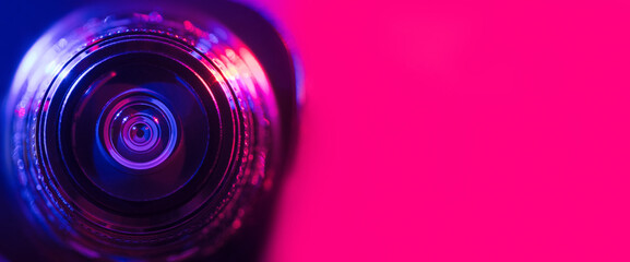 .Camera lens with purple and pink backlight. Banner