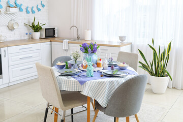 Dining table served for Easter celebration in kitchen interior