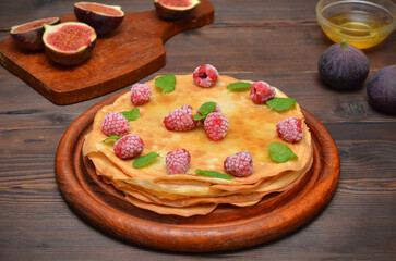 still life with thin pancakes with fruit on a wooden table
