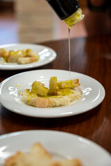 Tasting of Italian extra virgin olive oil with bread on organic farm in Tuscany, Italy