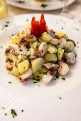 Tasty seafood salad with boiled octopus, potatoes, olive oil parsley served in Italian restaurant