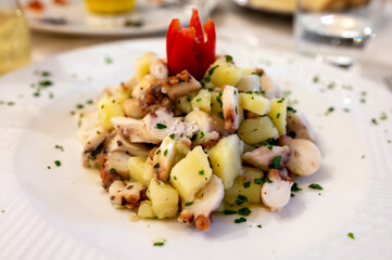 Tasty seafood salad with boiled octopus, potatoes, olive oil parsley served in Italian restaurant