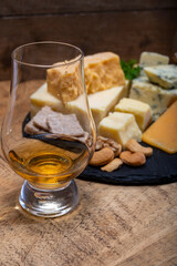 British drinks and food, glasses of Scotch whisky and cheeses collection, blue Stilton, Scottish coloured and English matured cheddar cheeses