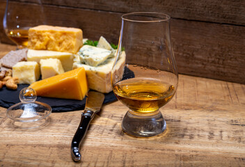 British drinks and food, glasses of Scotch whisky and cheeses collection, blue Stilton, Scottish coloured and English matured cheddar cheeses