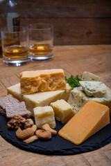 British drinks and food, glasses of Scotch whisky and cheeses collection, blue Stilton, Scottish coloured and English matured cheddar cheeses