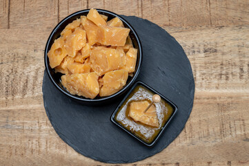 Cheese tasting, small pieces of old Dutch hard cheese and bowl with homemade dill-mustard sauce