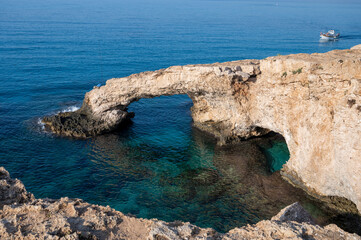 Tourists destination on Cyprus, natural arch Love Bridge and turquoise water of Mediterranean sea