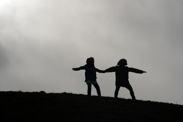 Father and daughter stand together on a hill and hang against the current