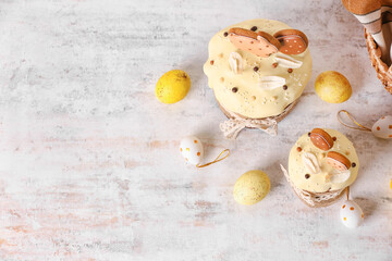 Delicious Easter cakes decorated with cookies and eggs on light background