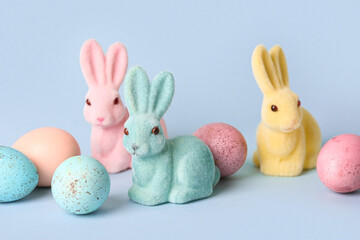 Easter bunnies and eggs on color background