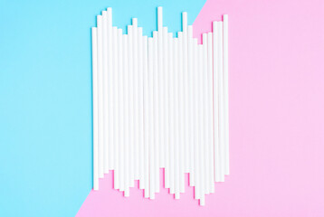 Paper straws for drinking on a pink and blue background close-up.