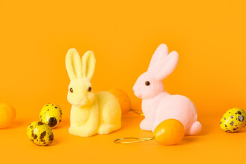 Cute Easter bunnies and eggs on color background