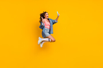 Fototapeta na wymiar Full size profile side photo of young excited girl use mobile share comment long socks isolated over yellow color background