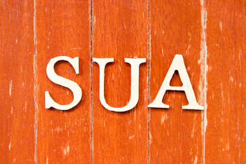 Alphabet letter in word SUA (Abbreviation of Single use account) on old red color wood plate...