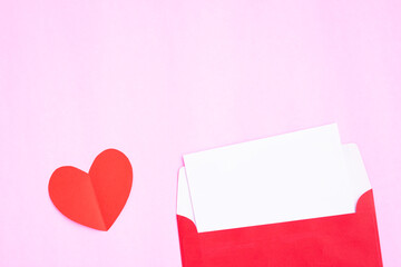 Red envelope with heart papercut on pink background