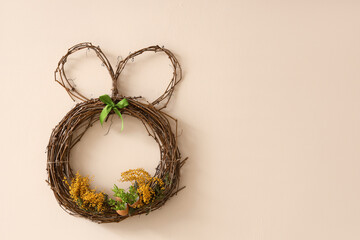Easter wreath with mimosa flowers on color wall