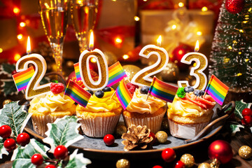 Food tray with cupcakes new year candles wineglasses and gay flags decorations