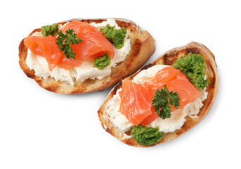 Delicious bruschettas with cream cheese, salmon and pesto sauce on white background, top view