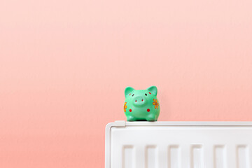 green piggy bank on radiator, save heating costs and money