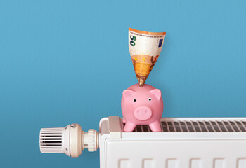 piggy bank on radiator with money bank notes, save heating costs