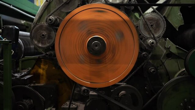Industrial mechanism. Big metal orange gears rotating. Inside of factory.