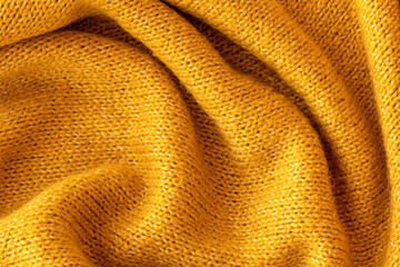 Soft knitted yellow sweater texture closeup. Light orange abstract background. Trendy soft...