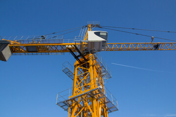 Tower crane against the blue sky. Tower crane operator's cabin. Crane operator at work.