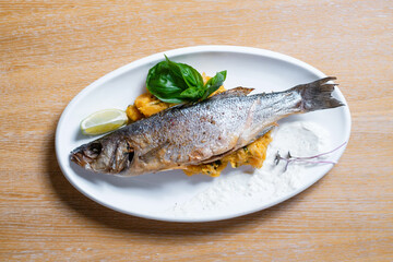 Fish baked with rice garnished with lime. Restaurant menu concept.
