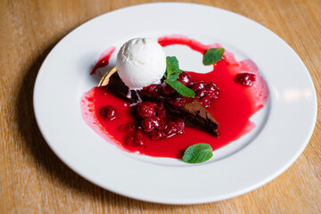 Chocolate brownie with cherries and ice cream. Sweet dessert.